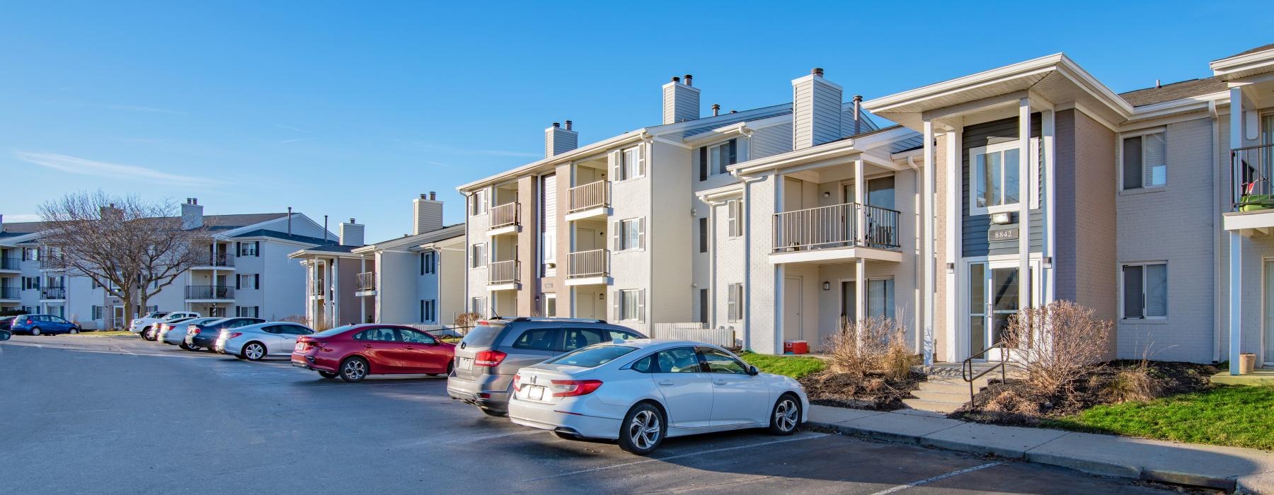 a row of cars parked in front of apartments
